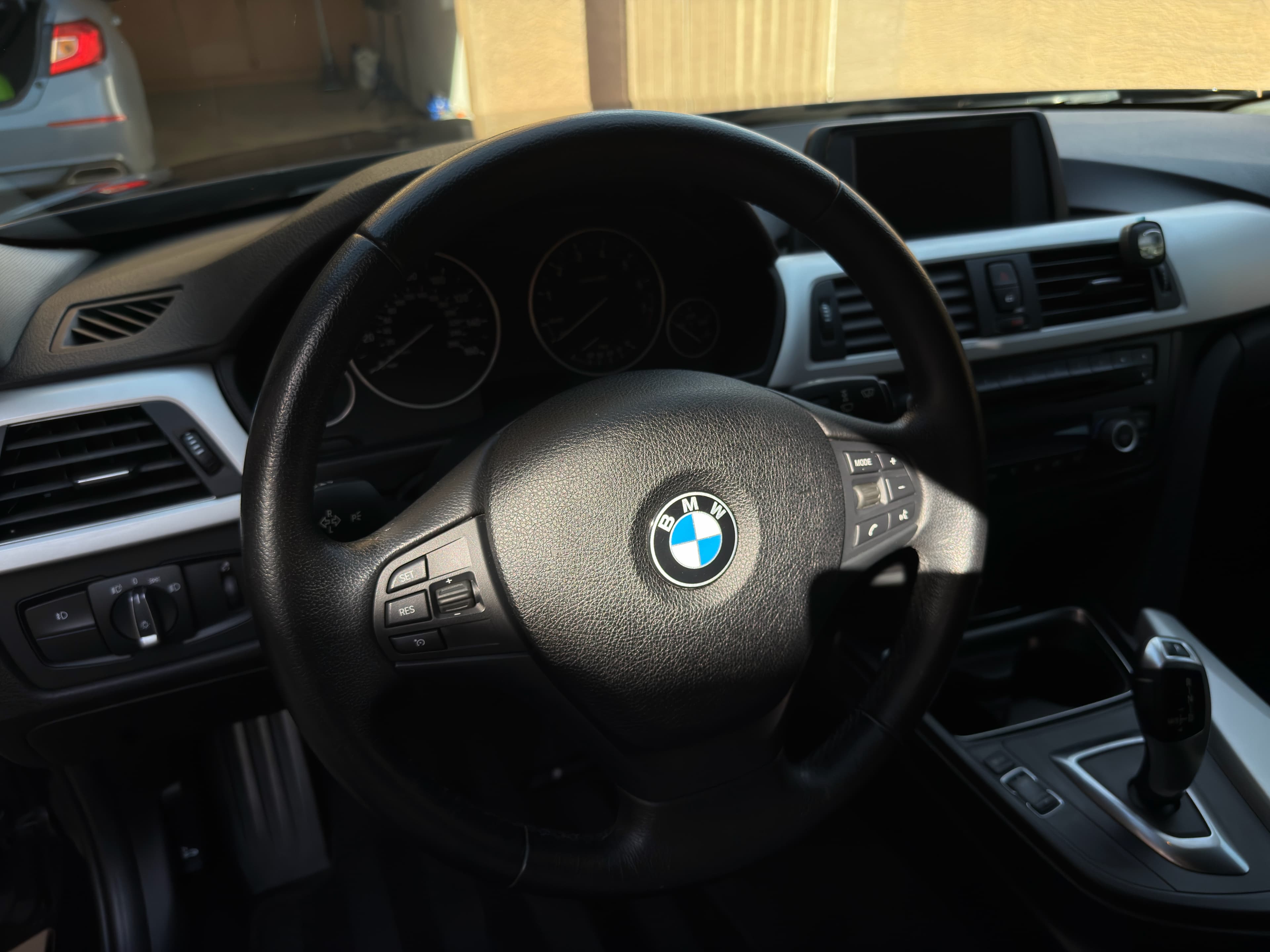 BMW driver cockpit — steering wheel and dashboard, detailed